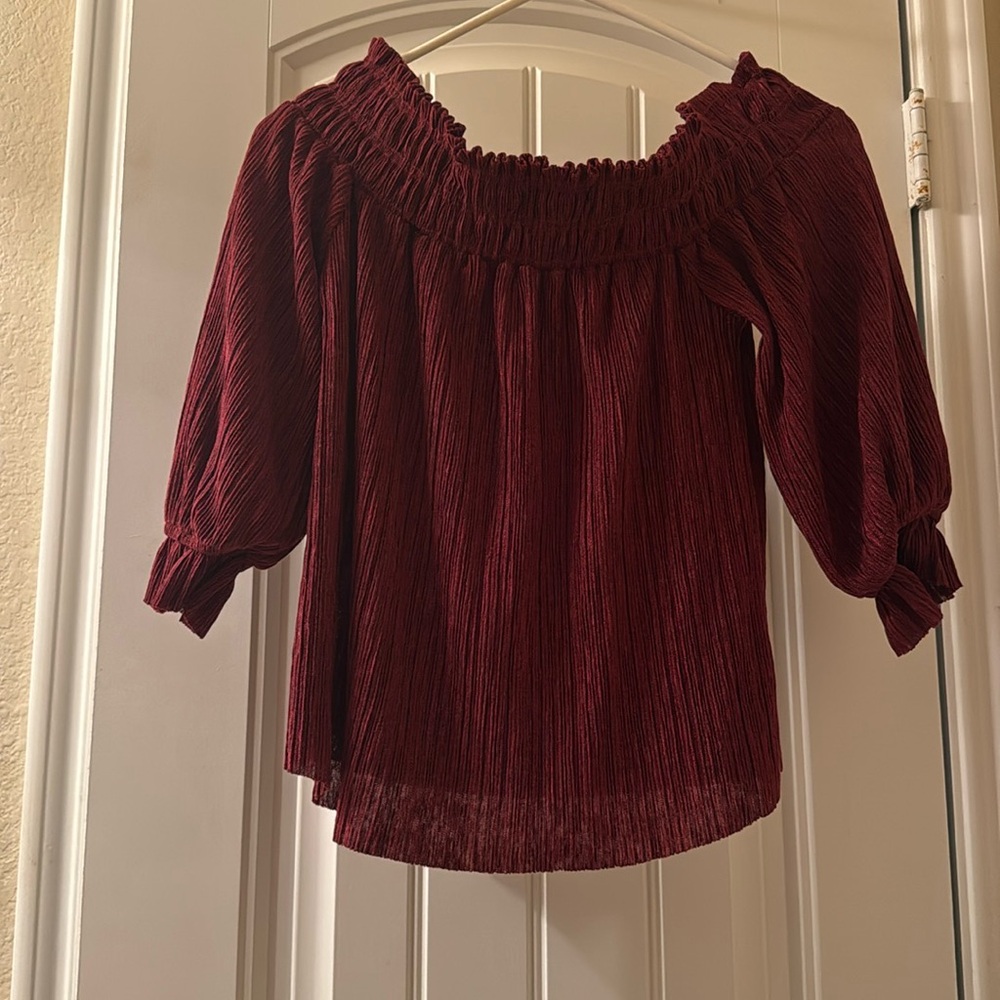 An over-the-shoulder maroon shirt